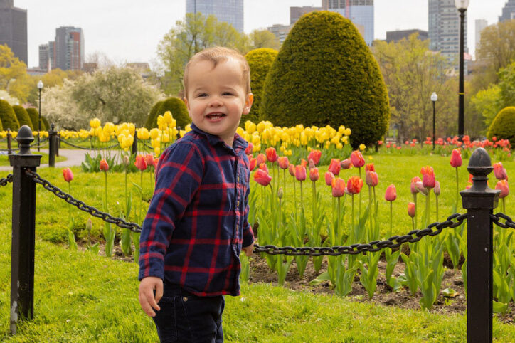 Micah se para cerca de unos tulipanes en el Boston Public Garden