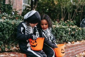   Dos niños mirando cubos de dulces de Halloween